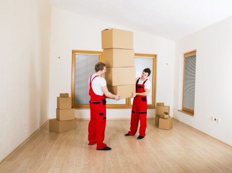 Professional movers carrying items through a narrow Islington staircase